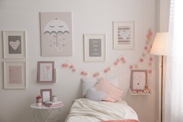 Stylish child's room interior with beautiful pictures and comfortable bed
