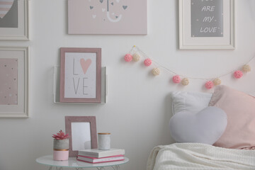 Beautiful pictures and stand with different accessories in stylish room interior