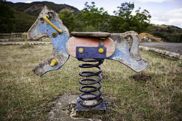 Abandoned rocking horse in playground