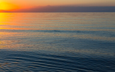 Obraz premium Dawn of the sun at sea. The rising sun behind the mountains. Kyrgyzstan.