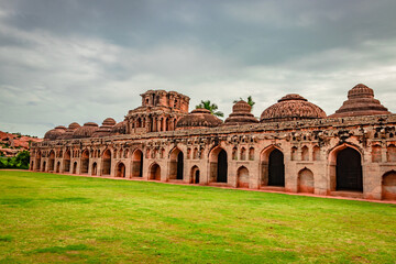 Fototapeta premium elephant stables hampi antique stone art with green grass floor from unique angle
