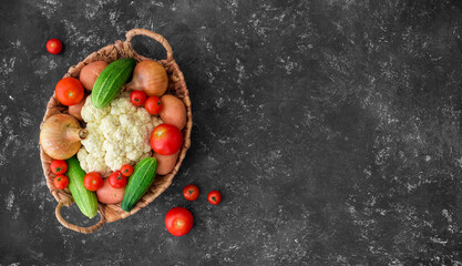 Fresh farm vegetarian and vegan vegetables in wicker basket on black background. Healthy food supermarket banner. Zero waste concept. Copy space