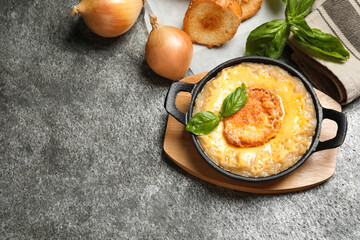 Tasty homemade french onion soup served on grey table, flat lay. Space for text