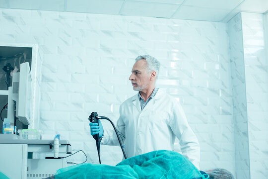 Worried doctor looking at the monitor of medical apparatus