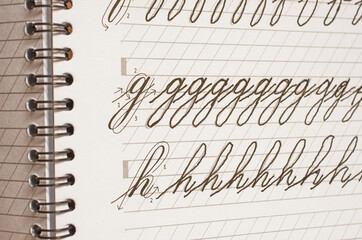 Page of a school notebook with handwritten letters of the English alphabet