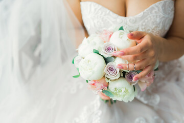 Bride holding big and beautiful wedding bouquet with flowers