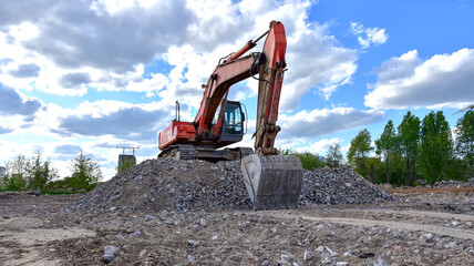 Naklejka premium Excavator work at landfill with concrete demolition waste. Salvaging and recycling building and construction materials. Industrial waste treatment plant. Reuse concrete for new construction