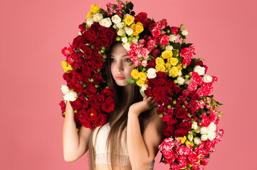 luxury woman with bouquet of roses on head on pink background