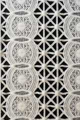 White lace. Close-up. Texture of white lace from cotton threads. Openwork. Linked pattern. Thread pattern. Geometric lace pattern. Seamless texture. Black background. Abstraction