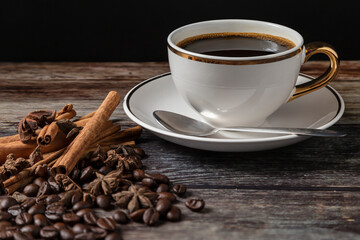 
Black coffee in a mug and roasted coffee beans placed on a wood-grain table.