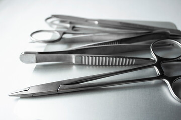 Surgical instruments on metal tray. Scalpel, clamp, scissors, surgical forceps on white background....