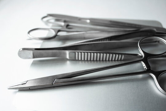 Surgical Instruments On Metal Tray. Scalpel, Clamp, Scissors, Surgical Forceps On White Background. Medical Instruments