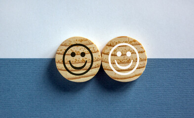 Racial equality concept. Wood circles with black and white smiles on white and blue background. Copy space.