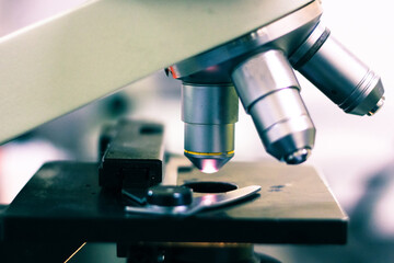 side view of a light microscope showing the light on and optical eye piece magnifiers