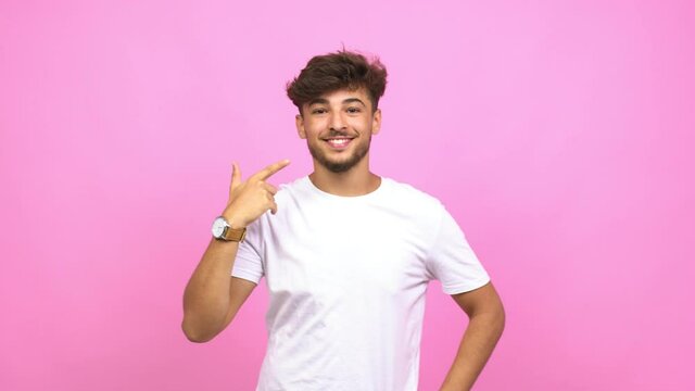 Young arab man smiles, pointing mouth, concept of perfect teeth, white teeth, has a cheerful and jovial attitude