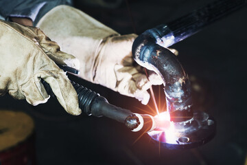 Close up of the hands welder worker by Tig. Flame, occupation selective focus