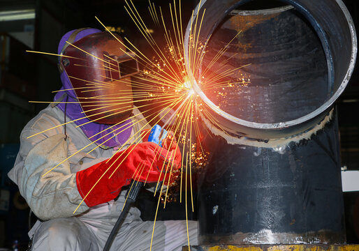 Workers welder welding on pipe line fabrication in factory