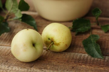 Delicious green apples with leaves on the table