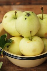 Delicious green apples with leaves on the table