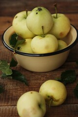Delicious green apples with leaves on the table