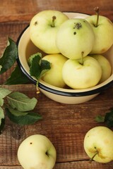 Delicious green apples with leaves on the table