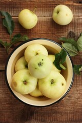 Delicious green apples with leaves on the table