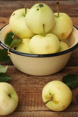 Delicious green apples with leaves on the table