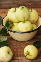 Delicious green apples with leaves on the table