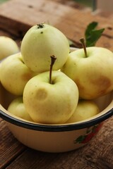 Delicious green apples with leaves on the table