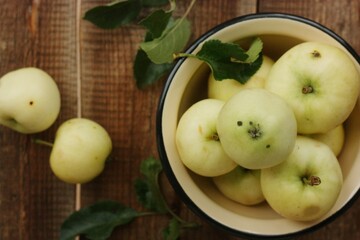 Delicious green apples with leaves on the table