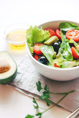 Fresh salad of avocado, cherry, arugula and olives made at home. Vegan food. The concept of healthy eating. Front view.