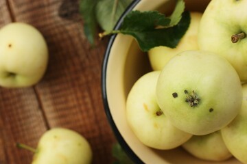 Delicious green apples with leaves on the table