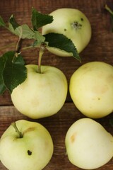 Delicious green apples with leaves on the table