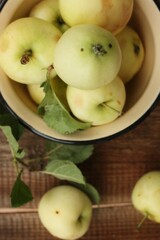 Delicious green apples with leaves on the table