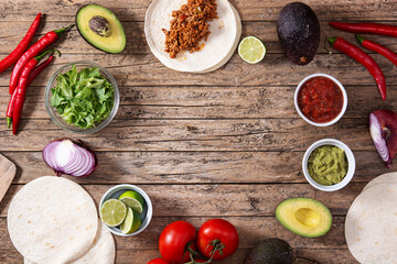 Mexican tacos ingredients on wooden table. Copy space