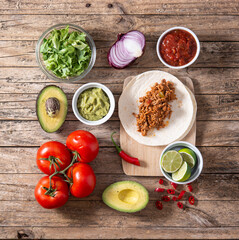 Mexican tacos ingredients on wooden table