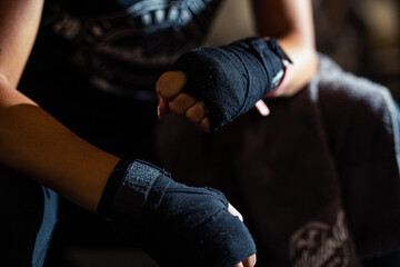Woman boxer wearing white strap on wrist.