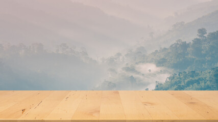 wooden tabletop with fall and autumn season design with mist on mountain background