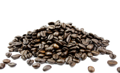 Coffee beans that have been roasted are piled on white