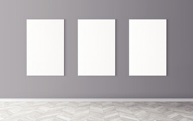 Three white empty canvases on wall. Mockup for you design preview. Good use for advertising materials.