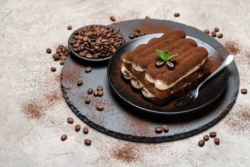 Classic tiramisu dessert on ceramic plate on concrete background