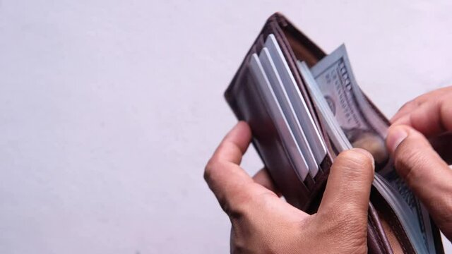 Close up of man hand taking 100 us dollar cash from a wallet 