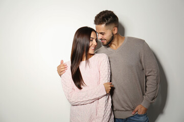 Lovely couple in warm sweaters on light background
