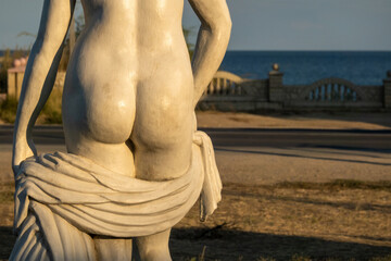 The lower fragment of a naked woman with a blanket in her hands against the background of the...