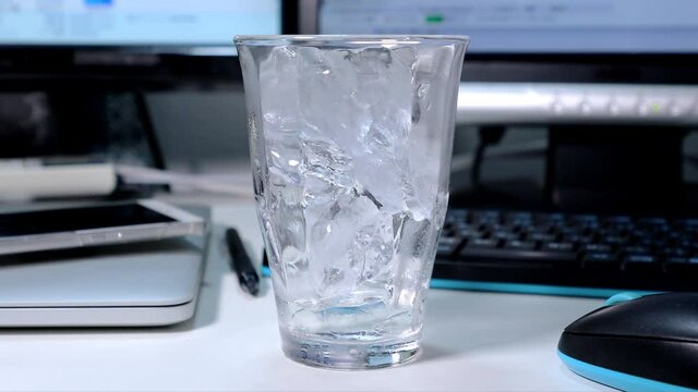 アイスコーヒーを氷の入ったグラスに注ぐ動画（引きの画角）