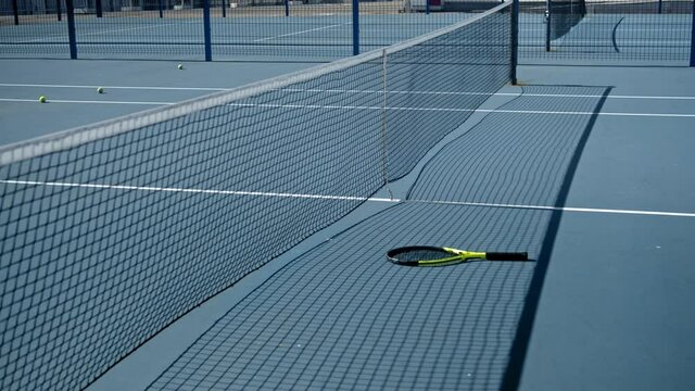 Stressed tennis player throwing and breaking a racket in anger and rage at court to net. Human emotions, defeat, crash, failure, loss concept. Professional Athlete Training, motivational video.