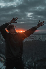 Fototapeta na wymiar Guy waves rocky against the sunset
