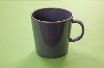 Coffee mug grey color on pastel green background. Hot beverage cup mockup template