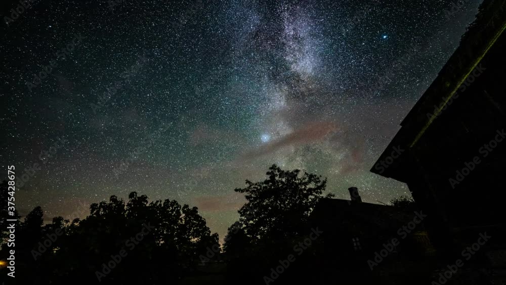 Wall mural timelapse of stars and milkyway over the trees at night. beautiful timelapse of milkyway. starfall.
