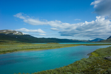 Obraz premium Swedish Lapland landscape. Turquoise water of Lake Alisjavri on Kungsleden and Nordkalottruta Arctic hiking Trail in northern Sweden. Arctic environment of Scandinavia in warm summer sunny day